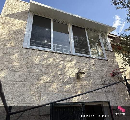 חלונות אלומיניום מותקנים על קיר אבן חיצוני